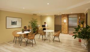 a man standing in a room with tables and chairs at Pegasy Apartments & Travel in Hanoi