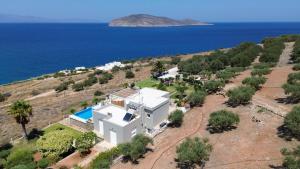 an aerial view of a white house with the ocean at Villa Tholos Crete in Kavoúsion