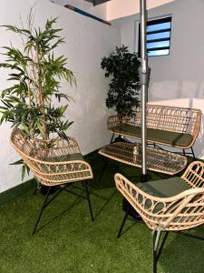 une terrasse avec une table, des chaises et des plantes dans l'établissement AZUR HOTEL, à Saint-Denis