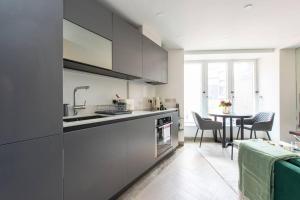 a kitchen with a sink and a table with chairs at Chic Central Reading 1BR Apt CHRL F2 in Reading