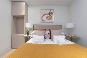 1 dormitorio con 1 cama grande con almohadas rojas y blancas en Chic Central Reading 1BR Apt CHRL F2 en Reading
