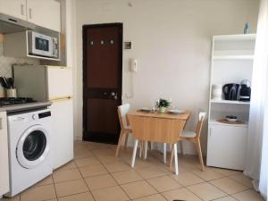uma cozinha com uma mesa e uma máquina de lavar roupa em Casa vicino Prato Della Valle em Pádua