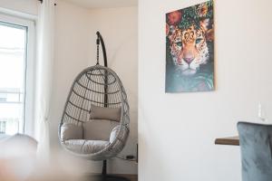 a hanging chair in a living room with a picture of a tiger at Premium Wohlfühloase Sinsheim - Business & Privat - Netflix & DisneyPlus - TG - Balkon in Sinsheim