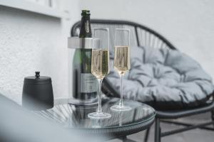 辛斯海姆的住宿－Premium Wohlfühloase Sinsheim - Business & Privat - Netflix & DisneyPlus - TG - Balkon，玻璃桌上的两杯酒和一瓶葡萄酒