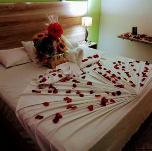 una cama con un montón de corazones rojos en ella en Astúrias Praia Hotel, en Guarujá