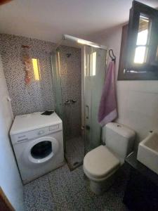 een badkamer met een toilet, een douche en een wastafel bij Magy's house in Batsi