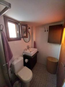 Łazienka z białą toaletą i umywalką w obiekcie Magy's house w mieście Batsi