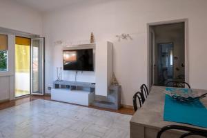 sala de estar con TV y mesa con sillas en Noemi House en Rapallo