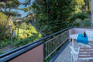balcón con mesa, sillas y árboles en Noemi House en Rapallo