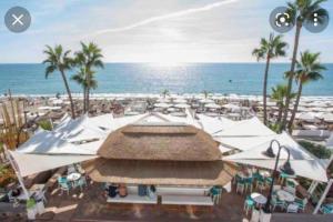 a view of a beach with umbrellas and the ocean at Magnífico Apartamento en La Carihuela, Torremolino in Torremolinos