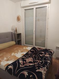 ein Schlafzimmer mit einem Bett und einem großen Fenster in der Unterkunft DANA S HOME in La Courneuve