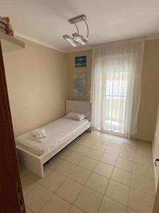 1 dormitorio con 1 cama en una habitación con ventana en Dellmar Apartment en Perea