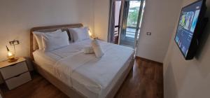 a bedroom with a white bed with a flat screen tv at Magnifique appartement à Riad Garden in Marrakech +35 photos