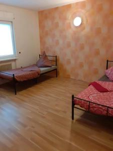 Cette chambre dispose de deux lits et de parquet. dans l'établissement Casa Mia Russotto 4, à Bruchköbel