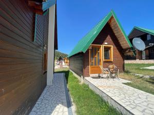 a house with a green roof and a patio at Small house Floki in Žabljak