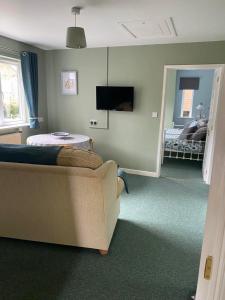 een woonkamer met een bank en een bed bij The Coach House at Copper Hall in Leominster