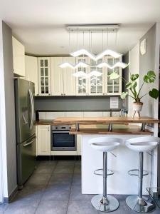 a kitchen with a refrigerator and a counter with stools at Super Apartment Paris Disneyland in Chessy