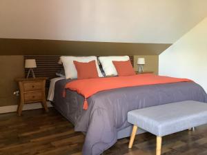 a bedroom with a large bed and a bench at LE JARDIN D'HILAIRE in LʼEntre-Deux