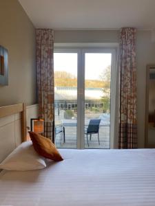 a bedroom with a bed with a view of a patio at Castel de Pont-a-Lesse in Dinant