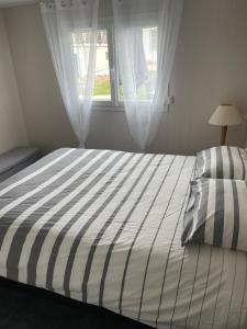 ein Schlafzimmer mit einem großen Bett mit Fenster in der Unterkunft Plage du Débarquement. Maison bord de Mer in Saint-Côme-de-Fresné