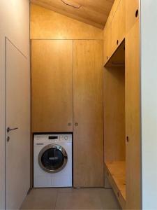 a washer and dryer in a closet with wooden cabinets at porichka in Korostov