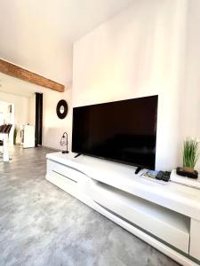 a large flat screen tv on a wall in a living room at La Verrière d'Opale - Maison proche plage et CNPE EDF in Grand-Fort-Philippe
