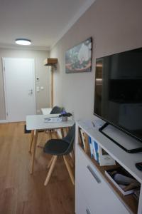 ein Wohnzimmer mit einem Tisch und einem großen TV in der Unterkunft HochgratBlick Modern.Gemütlich.Entspannt in Argenbühl