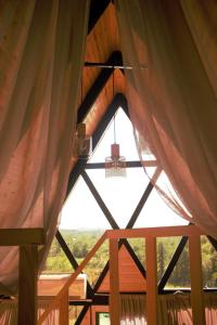 einen Blick von innen in einer Holzhütte mit Vorhängen in der Unterkunft Inn Martvili in Martvili