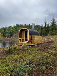 una casa de madera sentada en un campo junto a un río en Vidsyn Midjås, en Vistad