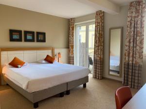 a bedroom with a large bed and a window at Castel de Pont-a-Lesse in Dinant