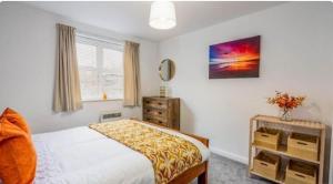 a bedroom with a bed and a dresser at 1 Merchants Gate - 2 bedroom, city apartment with private parking in York