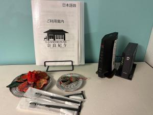 una mesa con un libro y un plato de comida en 奈良公園徒歩15分古民家リノベーション貸切一軒家 Guest House奈良紀寺, en Nara
