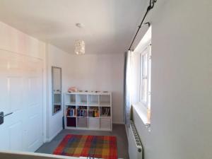 um corredor com uma estante de livros e uma janela em Tortoise Haven Bicester- Comfortable quiet home with garden em Stratton Audley