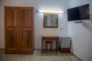 RidigamaにあるRaddegoda Walawwa Kurunegalaのキャビネット、テレビ、テーブルが備わる客室です。