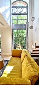 a yellow couch in a living room with a large window at City Garden in Wrocław