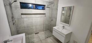 a bathroom with a shower and a toilet and a sink at Jock's Bay View in Bettyʼs Bay +27 photos