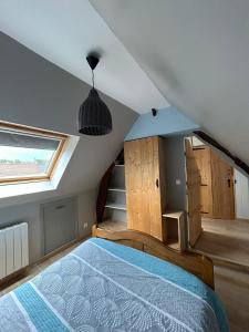 een slaapkamer op zolder met een bed en een raam bij La Nora Jolie in Tocqueville-sur-Eu
