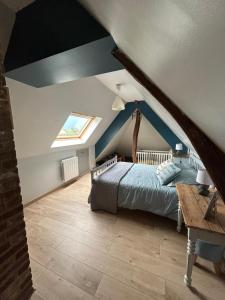 een slaapkamer op zolder met een bed en een dakraam bij La Nora Jolie in Tocqueville-sur-Eu