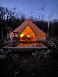 a tent with people in it on a wooden deck at Glamping 4 saisons @ Eco Lodge Bûcheron Bergère in Ormstown