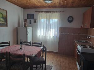 eine Küche mit einem Tisch und eine Küche mit einem Kühlschrank in der Unterkunft Vikendica Borje in Žabljak