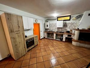 uma cozinha com armários brancos e piso em azulejo castanho em Open Space Il Rifugio em San Silvestro