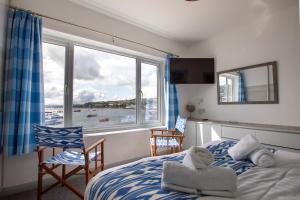 um quarto com uma cama e uma grande janela em Saltwhistle View- Beachside Luxury, Stunning Views em Teignmouth