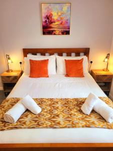 ein Schlafzimmer mit einem großen Bett mit orangefarbenen Kissen in der Unterkunft 1 Merchants Gate - 2 bedroom, city apartment with private parking in York