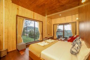 a bedroom with a bed and a large window at Sri Vidhya Residency by Indo Stays in Kotagiri
