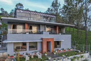 a house with a balcony on top of it at Sri Vidhya Residency by Indo Stays in Kotagiri