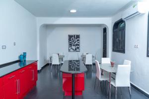 uma cozinha com armários vermelhos, uma mesa e cadeiras em Upendo Boutique Hotel, Dar es Salaam em Dar es Salaam