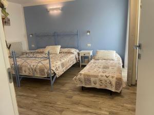コーリコにあるCorte del Lagoの青い壁とウッドフロアの客室で、ベッド2台が備わります。