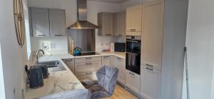 a kitchen with white cabinets and a marble counter top at Brand new Entire 4-Bed House in Peterborough in Peterborough