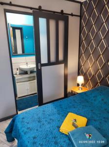um quarto com uma cama azul, um espelho e um lavatório. em Tranquillité & indépendance au coeur de la sologne em Lamotte-Beuvron