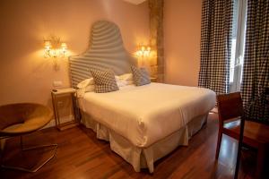 a bedroom with a large bed with a large headboard at Hotel Carmen Boutique in Baeza +44 photos